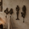 Brass mermaid wall hook set displayed on a textured wall with a hanging towel, coastal sea life nautical wall decor.