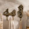 Brass mermaid double wall hook dimensions diagram showing width 6 inch (15.24 cm), height 6 inch (15.24 cm) and depth from wall 1 inch (2.54 cm). Handcrafted gold brass mermaid decorative coat hook and towel hook for coastal nautical home decor, beach house bathroom decor and housewarming gift