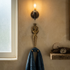 Solid brass mermaid double wall hook mounted in a candlelit bathroom with blue towel hanging — coastal bathroom towel hook and robe hook handmade in Ubud Bali