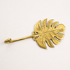 Gold brass monstera leaf wall hook isolated on white background, decorative leaf hook for home