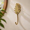 Brass Monstera leaf wall hook styled near a round rattan mirror, eclectic boho entryway decor idea