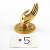 Gold brass Shuni mudra hand hook (Size 5) shown as sculptural hardware on white background.