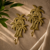 Multiple brass palm tree wall hooks in polished gold finish flat lay on warm textured fabric showing set and quantity options – palm tree coat hook key hook towel hook planter hook – tropical boho beach house coastal home decor – housewarming gift set – handcrafted solid brass Bali