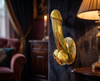 Brass penis door pull handle mounted as a wall hook in styled interior, cheeky statement decor hardware