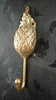 Close-up of brass pineapple wall hook showing detailed texture and finish