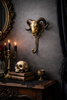 Brass ram skull wall hook styled in gothic dark academia room with moody vintage decor