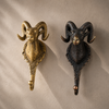 Solid brass ram wall hook in polished gold and antique brass finish displayed side by side on a neutral wall — decorative gothic wall hook handmade in Ubud Bali