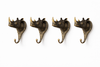 Set of 4 brass rhino wall hooks on white background, safari-inspired coat, towel and key hooks