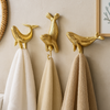 Brass sea life wall hooks set with whale and seal towel hooks in a coastal bathroom beach house decor