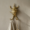 Close up brass sea shell wall hook holding towel coastal bathroom decor gold hook