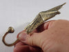 Artisan hand-finishing a brass sea star hook during casting in Bali