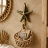 Brass sea star wall hook styled above a woven storage basket in a boho entryway