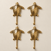 Set of 4 brass sea turtle wall hooks arranged in a grid, showing the detailed shell engraving from the nautical coat hook set.