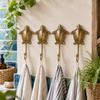 Set of 4 brass sea turtle wall hooks mounted on a tiled wall holding towels, handmade nautical coastal coat hook set.