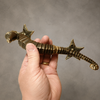 Hand holding a solid brass seahorse door pull from the matched set, showing natural size