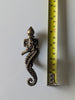 Brass seahorse wall hook next to measuring tape showing size for bathroom towel hook or nursery decor
