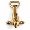 Top view of the brass seal bottle opener on a white background, showing the seal's head, outstretched flippers and the bottle-opening loop. A sculptural bar key and nautical bar decor piece, handmade in Bali.