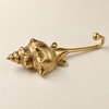 Side view of brass shell spiral hook showing the curved hook end on a cream background