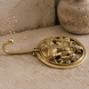 Side profile close-up of solid brass Lord Shiva wall hook showing circular disc depth and curved single hook extending from the base — brass Hindu hook yoga room spiritual decor hand cast in Ubud Bali