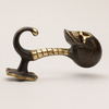Side view of solid brass skull hook in dark antique finish showing curved hook ribcage detail and mounting base on white background — gothic skeleton hook handmade in Bali