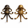 Two brass skull-octopus wall hooks side by side in a dark aged patina finish