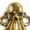 Close up of a brass skull-octopus wall hook in a polished gold finish