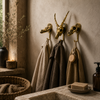 Three solid brass skull wall hooks styled in a moody bathroom with linen towels hanging — gothic dark academia towel hook set handmade in Ubud Bali