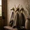 Three brass animal skull wall hooks styled in a boho entryway with bags hanging — gothic animal wall hook set for entryway handmade in Ubud Bali
