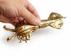 Hand holding a brass squid wall hook in a polished gold finish