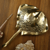 Brass stingray wall hook displayed flat on wood with seashells, styled as coastal decor from the handmade nautical hook set.