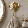 Gold brass stingray wall hook mounted near a round mirror holding a towel, from the handmade nautical coat hook set of 4.