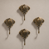 Set of 4 antique brass stingray wall hooks arranged flat, showing the full vintage-finish coat hook set for coastal wall decor.