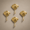 Set of 4 gold brass stingray wall hooks arranged flat, showing the full nautical coat hook set for coastal entryway decor.