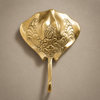 Gold brass stingray wall hook mounted on a beige wall, showing the detailed sea life engraving from the set of 4 coat hooks.