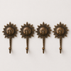 Set of 4 antique brass sun wall hooks in dark patina finish evenly spaced on white background – boho gallery wall hook set