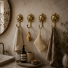 Four gold brass sun wall hooks styled in boho bathroom with hanging towels soap dispenser and mirror – decorative bathroom hook set

