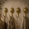 Set of 4 gold brass sun wall hooks mounted on warm textured entryway wall with hanging linen towels bags and jewelry – boho gallery wall decor