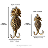 Side view of brass pineapple wall hook showing depth and double hook design