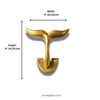 Brass whale tail wall hook used in an entryway holding a tote bag. Coastal nautical wall hook for bags, keys, and everyday storage in beach house or minimal homes