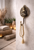 Brass Buddha wall hook used as towel holder in spa style bathroom with zen decor