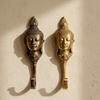 Pair of Buddha wall hooks mounted on wall for zen home decor, spiritual coat hanger and towel hook