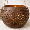 Carved coconut shell used as a hanging tea light candle holder