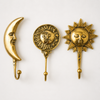 Set of 3 celestial brass wall hooks on white background showing size comparison – crescent moon hook sun and moon face hook and sun wall hook side by side in polished gold – handcrafted solid brass boho witchy celestial decor – astrology gift – made in Bali by UbudGlassandBrass