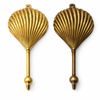 Clam shell wall hooks shown in gold and antique finishes for coastal home decor