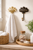 Brass seashell wall hooks styled in coastal bathroom holding white towels