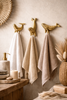 Coastal bathroom decor with brass whale and seal wall hooks used as towel holders beach house styling