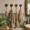 Coastal bathroom styled with towels and seashells beside a brass stingray wall hook, nautical decor for a beach house bathroom.