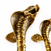 Close-up cobra head detail on solid brass snake door handle, textured luxury entry hardware