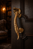 Solid brass cobra door handle installed on dark wooden entry door luxury gothic hardware