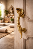 Brass cobra door pull installed on wooden door luxury entry hardware statement piece